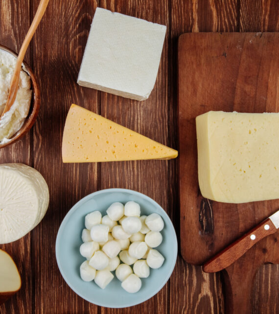 top view of different kind of cheese on rustic wooden background